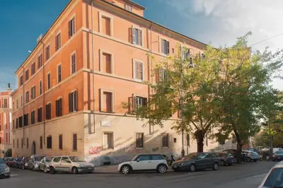 a large building with cars parked in front of it at FL Apartments Charming Flat in the heart of Trastevere in Rome