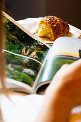 a person reading a book with a piece of bread on a plate at New Design St.Peter in Rome