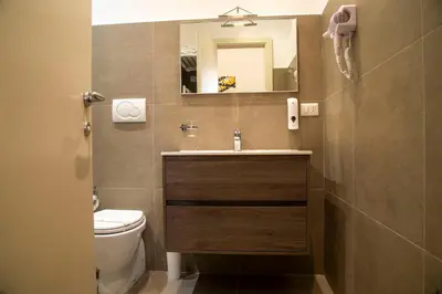 a bathroom with a sink and a toilet and a mirror at Rome Armony Suites in Rome