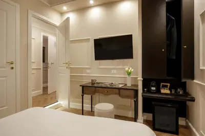 a bedroom with a bed and a television on the wall at Daplace - La Locanda di Piazza del Popolo in Rome
