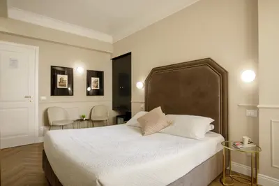 a bedroom with a large bed and two chairs at Daplace - La Locanda di Piazza del Popolo in Rome
