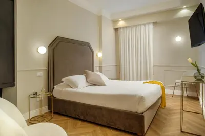 a hotel room with a bed and a tv at Daplace - La Locanda di Piazza del Popolo in Rome