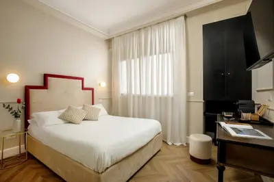a bedroom with a bed and a desk and a window at Daplace - La Locanda di Piazza del Popolo in Rome