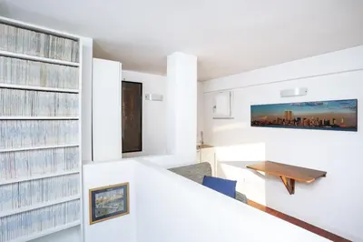 a room with white walls and a large wall of records at Enjoy the Sunset on Your Vatican Terrace in Rome