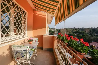 a balcony with a table and chairs and flowers at Enjoy the Sunset on Your Vatican Terrace in Rome