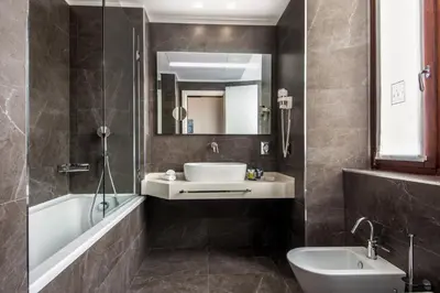 a bathroom with a sink and a toilet and a tub at Gioberti Art Hotel in Rome