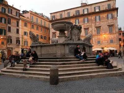 a group of people sitting on the steps of a fountain at Apartment in Trastevere im Herzen von Rom by Interhome in Rome