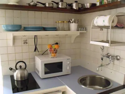a kitchen with a microwave with a bowl of fruit on it at Apartment in Trastevere im Herzen von Rom by Interhome in Rome