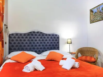 a large bed with orange and white towels on it at Apartment Charmantes- komfortables Studio im Herzen von Rom by Interhome in Rome