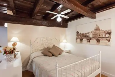 a bedroom with a white bed and a ceiling fan at House&Colosseum in Rome