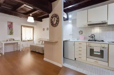 a kitchen with white cabinets and a table in a room at House&Colosseum in Rome