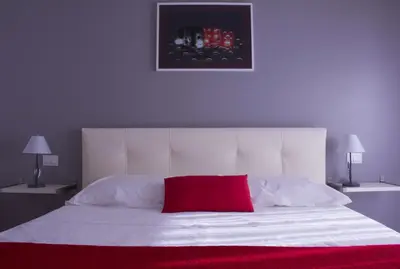 a bedroom with a white bed with a red pillow at Domus Raffaello in Rome