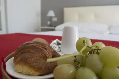 a plate of food with a croissant and grapes at Domus Raffaello in Rome
