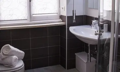 a bathroom with a sink and a toilet and a window at Domus Raffaello in Rome