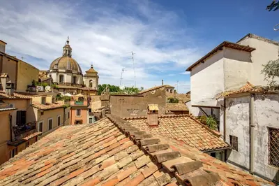a view of roofs of buildings with a cathedral in the background at The Right Place 4U Navona Luxury Rooms in Rome