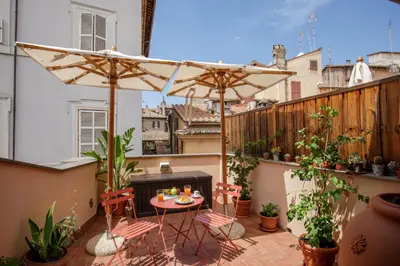 a balcony with a table and two umbrellas at The Right Place 4U Navona Luxury Rooms in Rome