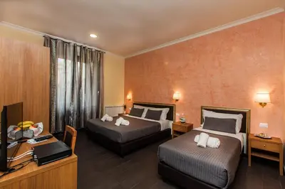 a hotel room with two beds and a television at Guest's Heaven in Rome