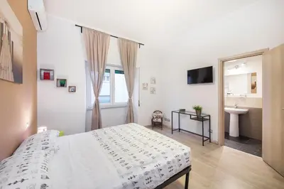 a white bedroom with a bed and a sink at Rome To You- The Place to be&B in Rome