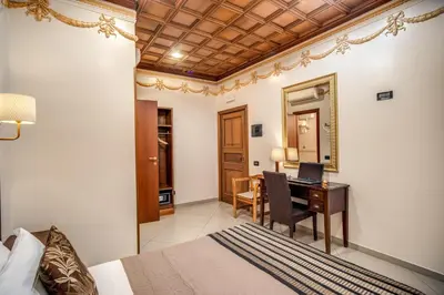 a bedroom with a bed and a desk with a computer at Artemis in Rome