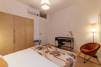 a bedroom with a bed with a chair and a desk at Appartamento moderno e silenzioso a Trastevere in Rome