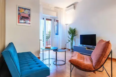 a living room with a blue couch and a tv at Vivace appartamento con splendido giardino in Rome