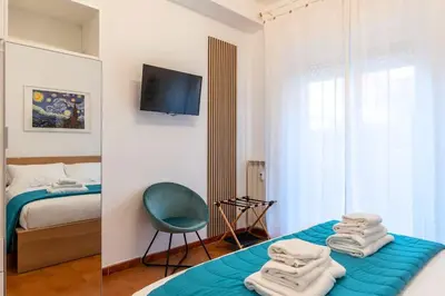 a bedroom with a bed and a chair and a television at Vivace appartamento con splendido giardino in Rome