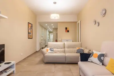 a living room with two white couches and a television at Nuovo e ampio appartamento vicino metropolitana in Rome