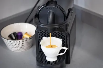 a coffee maker is pouring coffee into a cup at Nuovo appartamento ben collegato con il centro in Rome