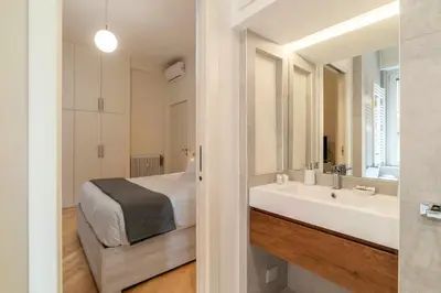 a bedroom with a bed and a bathroom with a sink at Appartamento moderno a 5 minuti dal Vaticano in Rome