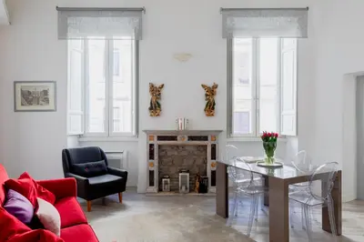 a living room with a red couch and a fireplace at Domus Degli Angeli in Rome