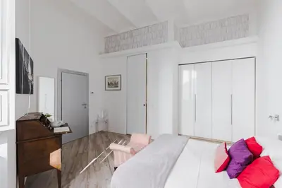 a bedroom with a large bed with red and purple pillows at Domus Degli Angeli in Rome