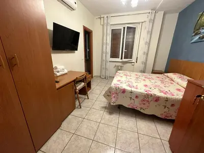 a bedroom with a bed and a desk and a television at Sofia Holiday Home in Rome