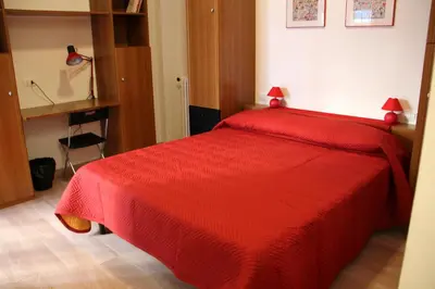 a bedroom with a red bed with a red blanket at Lo Studio Guest House in Rome