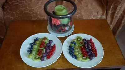 two plates of fruit on a table with a vase at Terrazza San Pietro in Rome