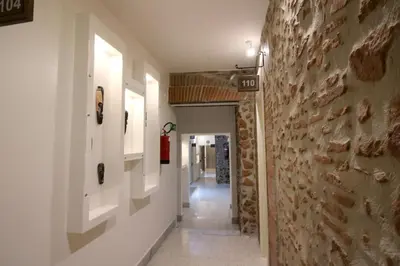 a hallway in a building with a stone wall at NEW GENERATION HOSTEL Rome center in Rome