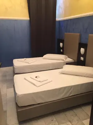 three beds in a room with white sheets at NEW GENERATION HOSTEL Rome center in Rome