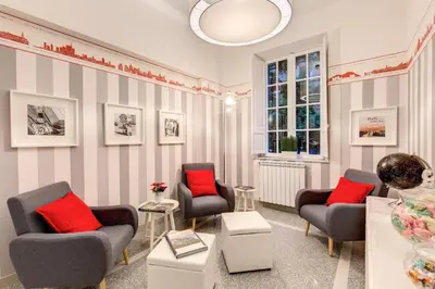 a living room with two chairs and red pillows at Grand Tour Rome Suites - Liberty Collection in Rome