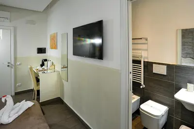 a bathroom with a toilet and a tv on the wall at Domus Castroni Pompeo Magno in Rome