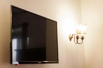 a flat screen tv hanging on a wall next to a mirror at TrastEver Holiday in Rome