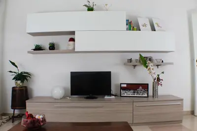 a living room with a tv on a wooden entertainment center at Vatican In The Moonlight Apartment in Rome