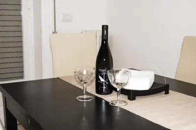 a bottle of wine sitting on a table with two wine glasses at Vatican In The Moonlight Apartment in Rome