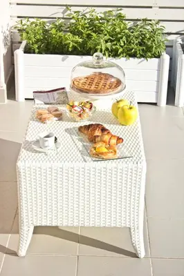 a white wicker table with bread and pastries on it at Glamroom Luxury Terrace in Rome