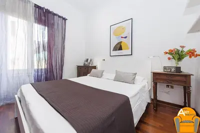 a bedroom with a bed and a table and a window at 4BNB - Vatican Doors Flat in Rome