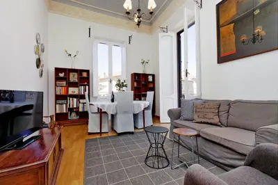 a living room with a couch and a table at Spagna Penthouse in Rome