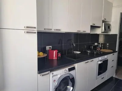 a kitchen with white cabinets and a washing machine at B&B Vaticanrooms in Rome
