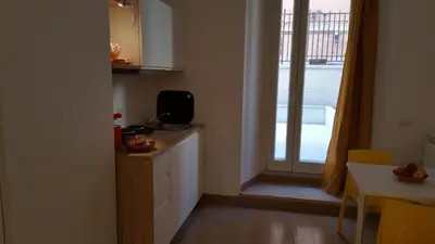 a kitchen with a counter and a window and a table at La Casetta di Ely in Rome