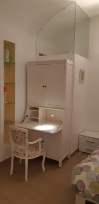 a bedroom with a desk with a chair and a mirror at La Casetta di Ely in Rome