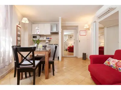 a living room with a table and a red couch at Apartment Via Giulia in Rome