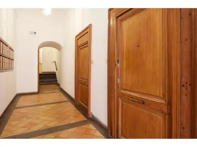 a hallway with two wooden doors and a staircase at Apartment Via Giulia in Rome