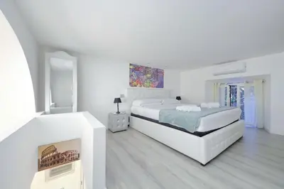 a white bedroom with a bed and a fireplace at 4BNB - Domus Colosseo in Rome